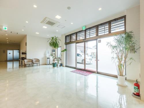 an empty lobby with potted plants in a building at Hotel Isesaki East in Isesaki