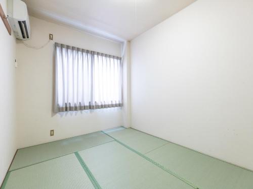 an empty room with a window and green floor at Hotel Isesaki East in Isesaki