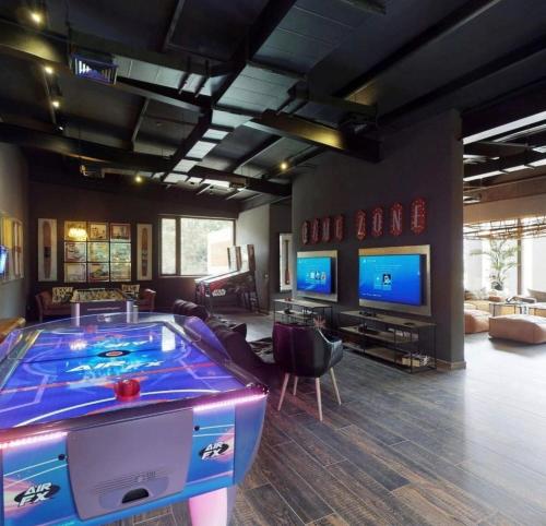 a large room with a video game room with a pool table at DEPTO PARQUE PINARES FRENTE AL LAGO, PRIMERA LINEA, NUEVO in Pucón