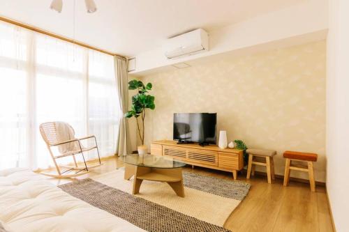 a living room with a couch and a tv at Akiba Residence in Tokyo