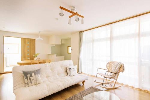 a living room with a white couch and a chair at Akiba Residence in Tokyo