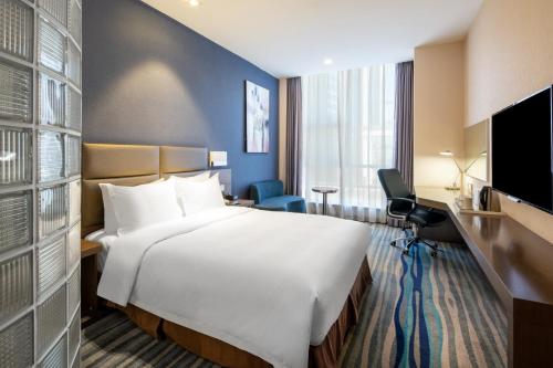 a hotel room with a large bed and a television at Holiday Inn Express Shenyang North Station by IHG in Shenyang