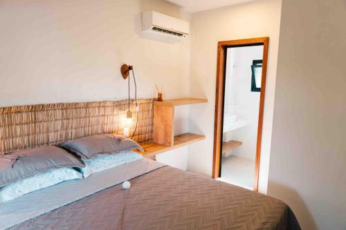 een slaapkamer met een bed en een spiegel bij Marafunda Hospedaria, Praia da Gamboa in Garopaba