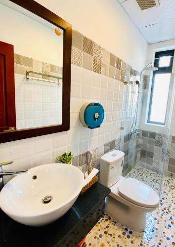 a bathroom with a sink and a toilet and a mirror at HOTEL ĐỨC THÀNH 2 in Con Dao