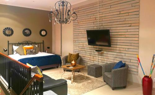 Un dormitorio con una cama y un televisor en una pared. en Franschhoek Studio, en Franschhoek