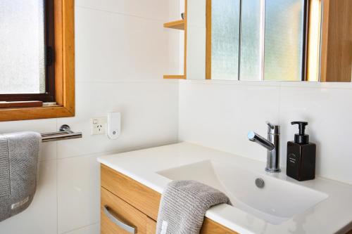 ein Bad mit einem Waschbecken und einem Spiegel in der Unterkunft Siver Cabin in Kangaroo Valley