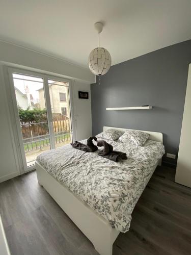 une chambre avec un lit avec un animal en peluche dessus dans l'établissement La digue 45 Rue des Lais de Mer, à Benerville-sur-Mer