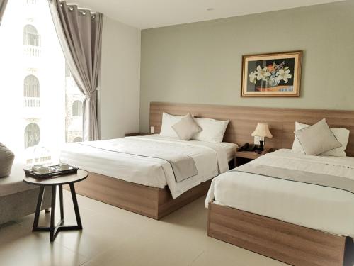 Postel nebo postele na pokoji v ubytování An Hoi Canary Hotel