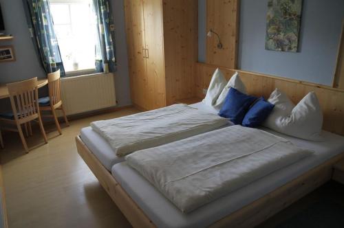 a large bed with white sheets and blue pillows at Lindenhof- Fam. Forstmayr in Haag