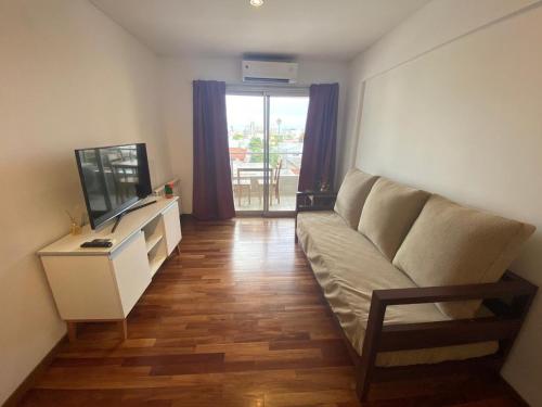 uma sala de estar com um sofá e uma televisão em Luxury Appart em Salta