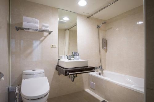 a bathroom with a toilet and a sink and a tub at 台北碧瑤飯店 Hotel B in Taipei
