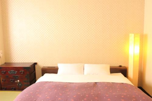 a bedroom with a bed and a wall with polka dots at K's House Tokyo Oasis - Asakusa Downtown in Tokyo