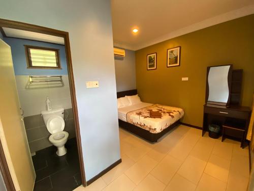 ein Schlafzimmer mit einem Bett und einem WC darin in der Unterkunft Redang De' Rimba in Pulai Redang