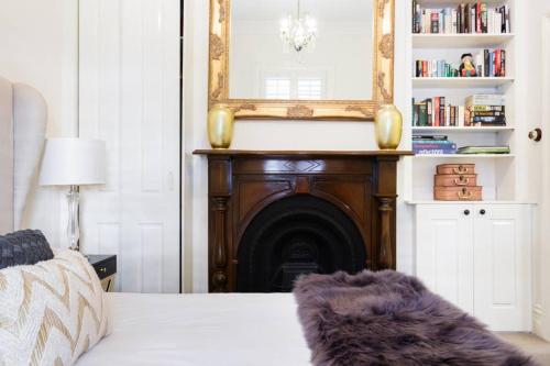 a bedroom with a fireplace with a mirror and a bed at 94 Highett - 5 bedroom, 3 car parks - Luxury House in Melbourne