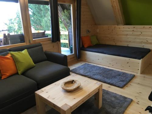 ein Wohnzimmer mit einem Sofa und einem Couchtisch in der Unterkunft Wooden Apartman Prémium Jacuzzival in Alsóörs