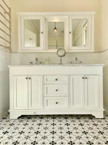 a white bathroom with a sink and mirrors at 94 Highett - 5 bedroom, 3 car parks - Luxury House in Melbourne