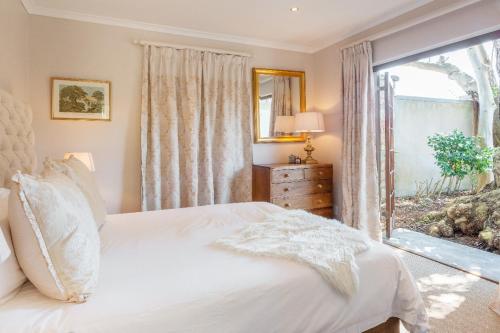 a bedroom with a bed and a large window at Aloe Cottage at Ibis House in Cape Town