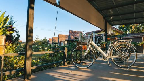 a bike is parked on a sidewalk next to a fence at Baan Sin Suk in Chiang Rai