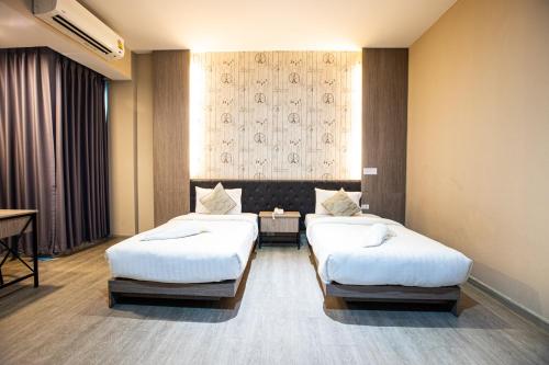 a hotel room with two beds and a window at Tara Park Resotel in Ban Talat Rangsit