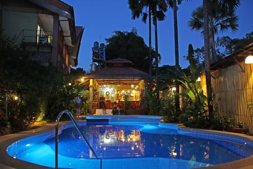 a swimming pool in front of a house at night at Darayonan Lodge in Coron