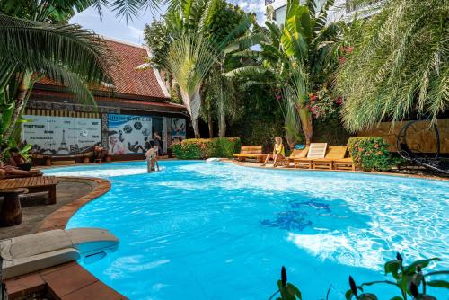 a large swimming pool with people in a resort at Naiharn Pearl Condo Hotel by VillaCarte in Nai Harn Beach