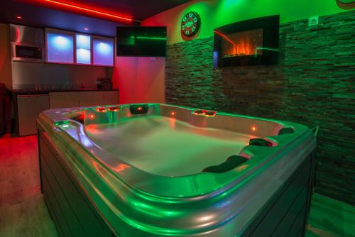 a jacuzzi tub in a room with a fireplace at American spa motel in Joncherey