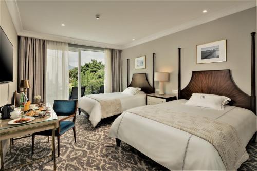 Pokój hotelowy z 2 łóżkami, biurkiem i stołem w obiekcie Royal Blue Hotel w Dubrowniku