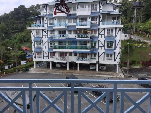 a large white building with blue balconies at Homstay Desa Anthurium in Tanah Rata