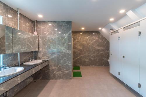 a bathroom with two sinks and a stone wall at The Victory View in Bangkok