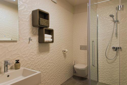 a bathroom with a shower and a toilet and a sink at Aldilà Art Rooms, Apartment and Vacation House in Šmartno