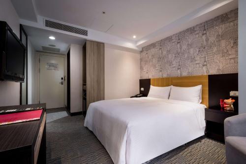 a hotel room with a large bed and a flat screen tv at 台北碧瑤飯店 Hotel B in Taipei