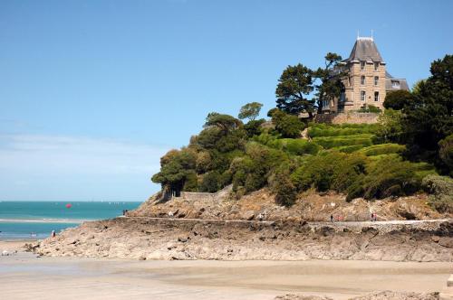 a house on top of a hill next to the ocean at Studio Winston in Dinard