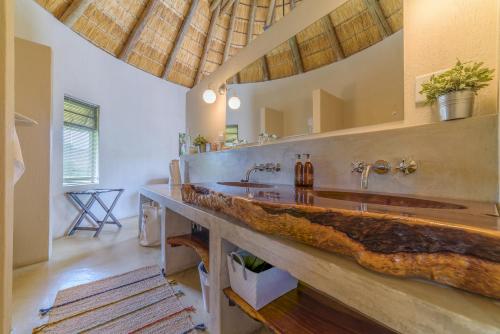 Lengau Lodge في Grietjie Game Reserve: حمام مع منضدة حجرية كبيرة مع مغسلتين