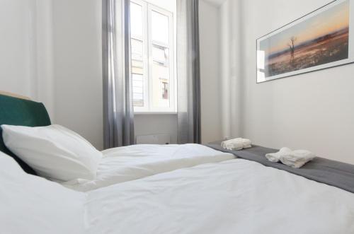 a white bed in a room with a window at Apartament Mickiewicza in Wadowice