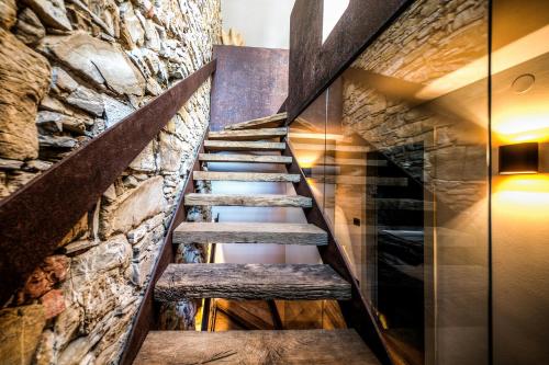 a staircase in a room with a stone wall at Aldilà Art Rooms, Apartment and Vacation House in Šmartno