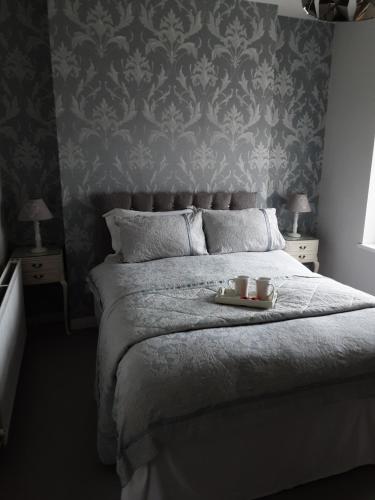 a bedroom with a bed with two candles on it at Esplanade Seaside View Apartment in Porthcawl