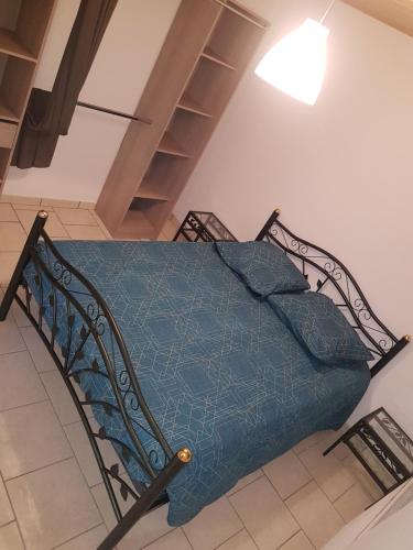 1 cama con edredón azul en una habitación en gite des jardiniers en Fumay