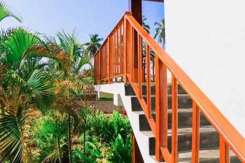a wooden staircase leading up to a building with palm trees at ANB Surf View in Tangalle