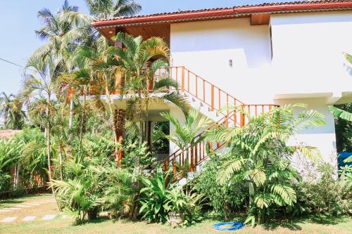 a house with palm trees in front of it at ANB Surf View in Tangalle