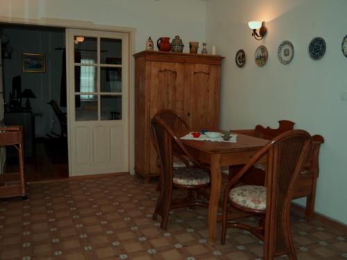 a dining room with a wooden table and chairs at CSONGRÁDI VENDÉGVÁRÓ Apartmanok, Szarka ház in Csongrád