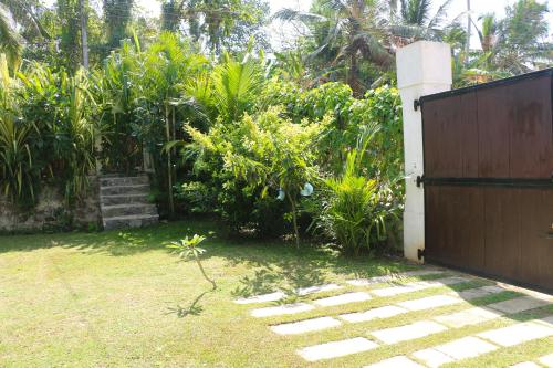 a garden with a wooden gate and some plants at ANB Surf View in Tangalle