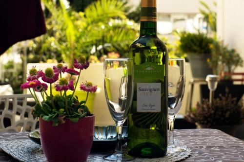 une bouteille de vin posée sur une table avec deux verres dans l'établissement Hôtel Bellevue Cannes, à Cannes