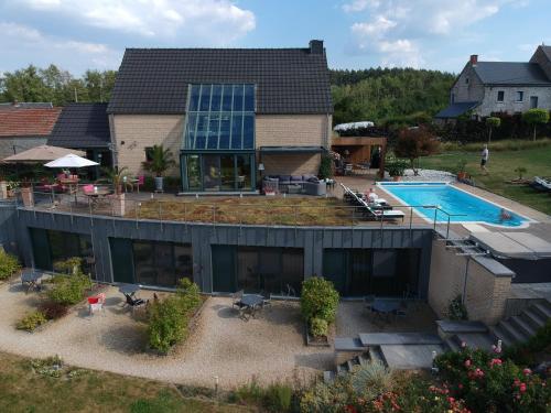 una vista aérea de una casa con piscina en B&B Le Bouchat-Oreille, en Spontin