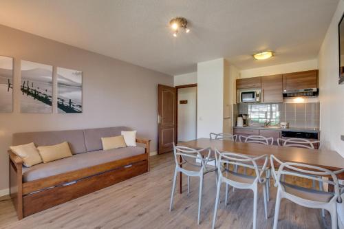 a living room with a table and a couch at Résidence Azurea in Aix-les-Bains