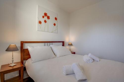 a bedroom with a white bed with towels on it at Résidence Azurea in Aix-les-Bains