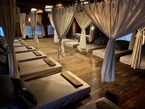 a room with rows of beds with curtains at Pu Luong Ecocharm in Hương Bá Thước