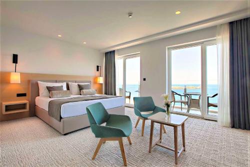 a bedroom with a bed and a room with a balcony at Royal Neptun Hotel in Dubrovnik