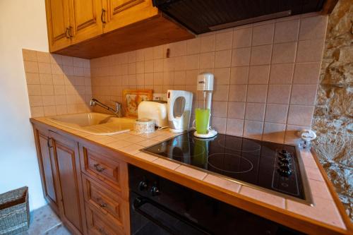 a kitchen with a sink and a stove top oven at Constantias stone houses in Lofou