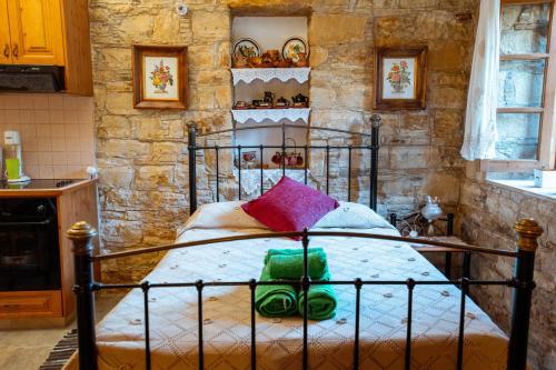 a bedroom with a bed in a stone wall at Constantias stone houses in Lofou