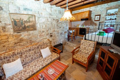 a living room with a couch and a bedroom at Constantias stone houses in Lofou